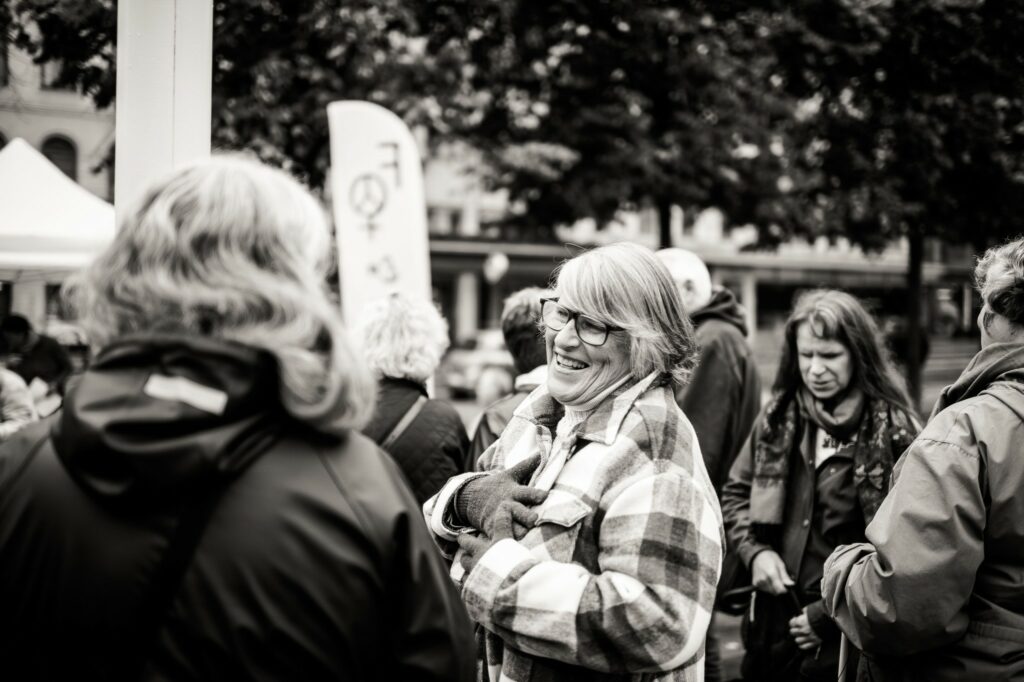 Svartvitt foto. Människor börjar samlas, samtalar. På bilden syns bland andra Karin Hjalmarson och Tiina Nummi-Södergren.
